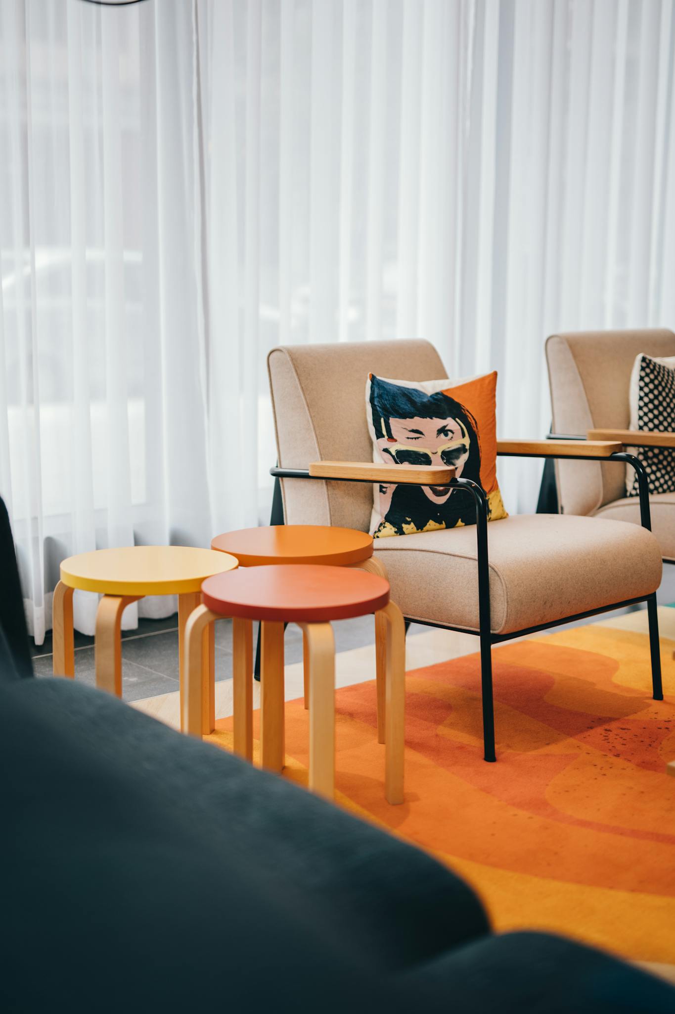 Contemporary living room with vibrant orange accents and modern armchairs.