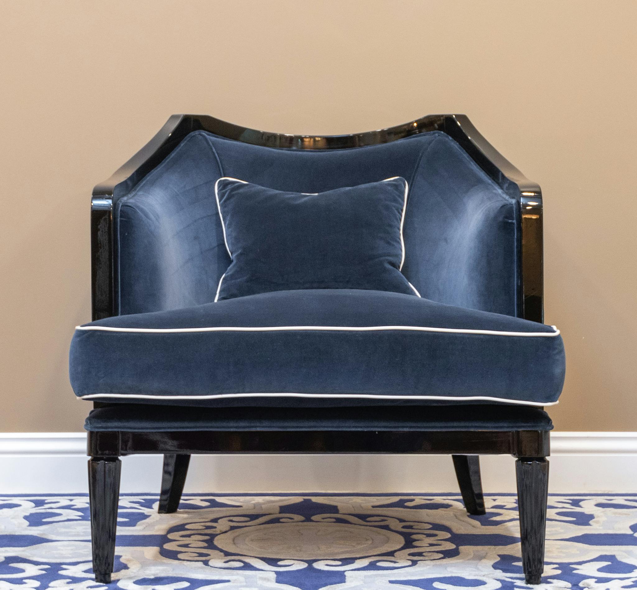 Luxurious blue velvet armchair with decorative patterns, ideal for elegant interior decor.